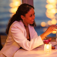 Un couple romantique et souriant dégustant un repas bistronomique avec vue sur les lumières de la ville