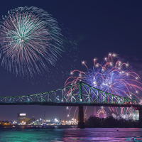 Vue sur la tour de l'horloge et le pont Jacques Cartier à Montréal avec des feux d'artifice majesteux surplombant les monuments