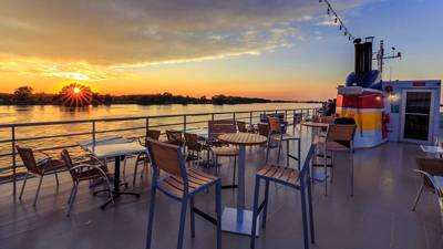 Terrasse extérieur du pont supérieur du navire AML Louis Jolliet à Québec avec vue sur le fleuve Saint-Laurent et un beau coucher de soleil en arrière plan