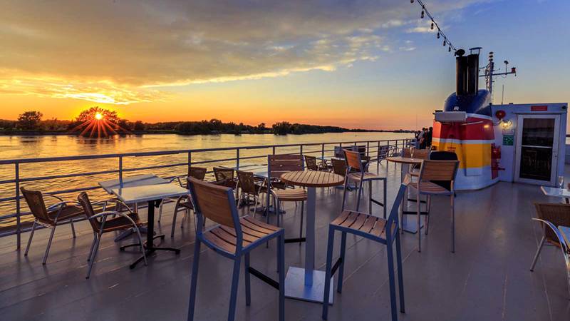 Terrasse extérieur du pont supérieur du navire AML Louis Jolliet à Québec avec vue sur le fleuve Saint-Laurent et un beau coucher de soleil en arrière plan
