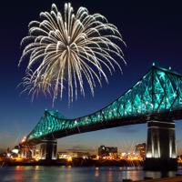 Jacques Cartier Bridge in Montreal at night, illuminated with fireworks overhead, overlooking the monument