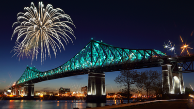 Pont Jacques Cartier à Montréal de nuit et éclairé, avec des feux d'artifice surplombant le monument 