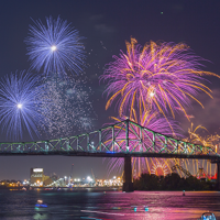 Vue sur la tour de l'horloge et le pont Jacques Cartier à Montréal avec des feux d'artifice surplombant les monuments