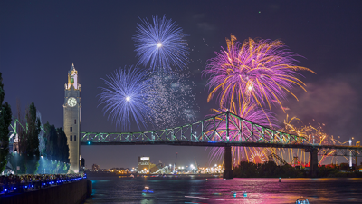 Vue sur la tour de l'horloge et le pont Jacques Cartier à Montréal avec des feux d'artifice surplombant les monuments
